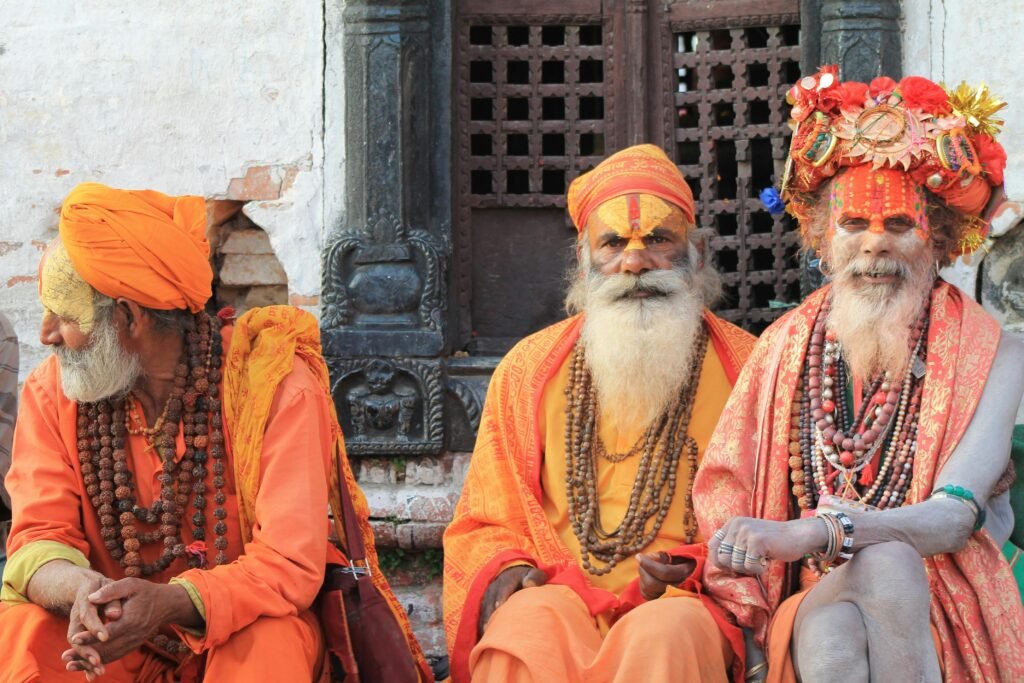 Three sadhus in traditional attire at Pashupatinath Temple, Nepal, exemplifying vibrant cultural heritage.
